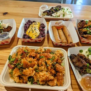 L to R: Laotian sausage, mango sticky rice, chicken egg rolls, garlic chicken wings. Bottom: crispy fried rice and ribeye skewers