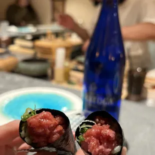 a person holding a piece of sushi