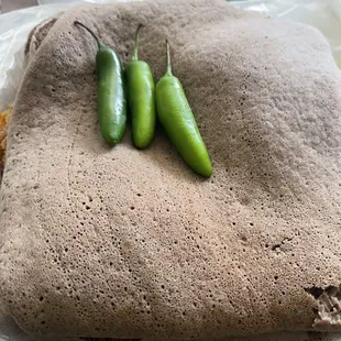 a burrito with two green peppers on top