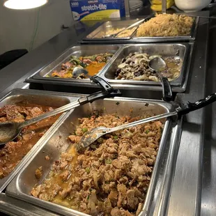 a variety of food being served at a buffet