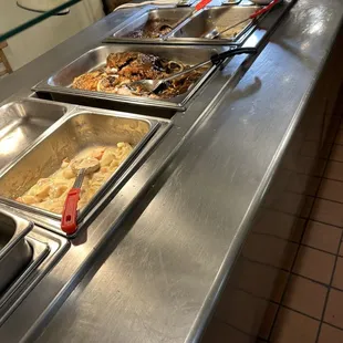 a line of food being served at a buffet