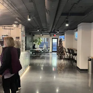 a woman and a man standing in an office lobby