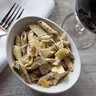 a bowl of pasta and a glass of wine