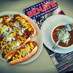 a plate of chili dogs and a bowl of chili
