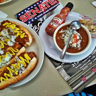 a plate of chili dogs and a bowl of chili