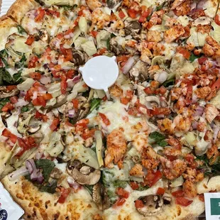 Vegetarian pizza on one side and with chicken on the other side.