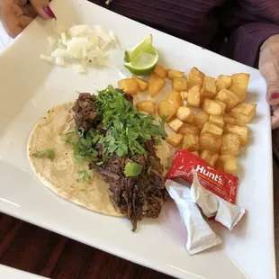 Barbacoa taco with &quot;hash browns&quot;. Although they didn&apos;t get the hash brown part right, the potatoes were perfectly crispy and DELISH