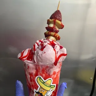 a hand holding a cup of ice cream