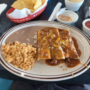 Beef enchilada dinner with rice and beans.