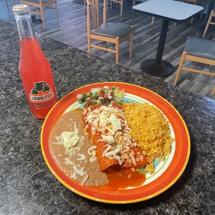a plate of mexican food and a bottle of soda