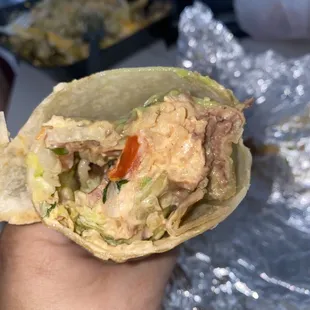 a hand holding a burrito