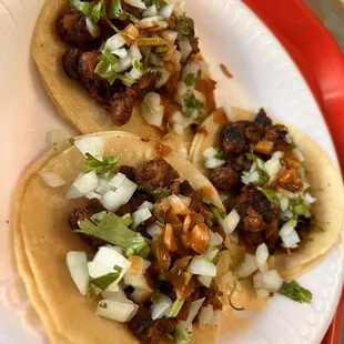 three tacos on a paper plate