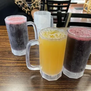 three glasses of juice on a table