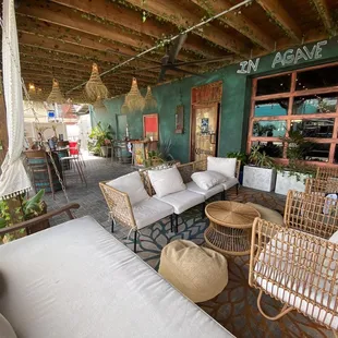 A little living room, waiting area with 2 swings, garage door that opens, and further in the picture are high top tables