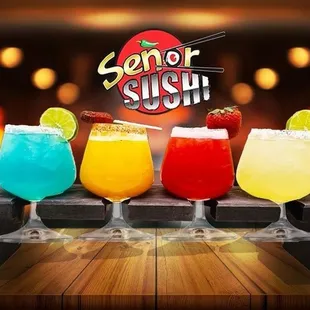 four different cocktails on a wooden table