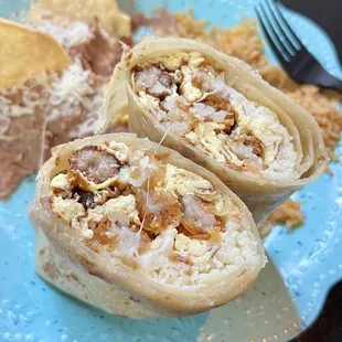 Inside of a breakfast burrito with eggs, hash browns, cheese and sausage.