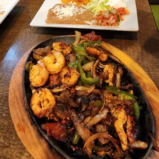 Steak, chicken, and shrimp fajitas with rice and beans.