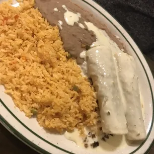 Two veggie enchiladas with onions, peppers, and jalepeños inside topped with yummy queso.