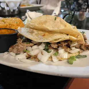 a plate of pulled pork and tortillas