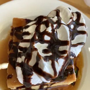 Flan with whipped cream and chocolate syrup