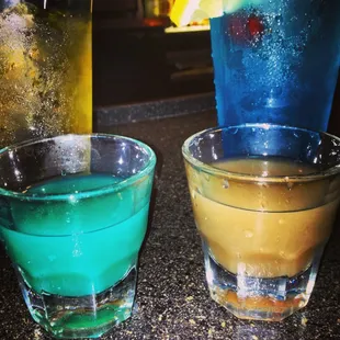 two glasses of different colored drinks