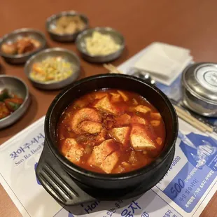 a bowl of soup and bowls of vegetables