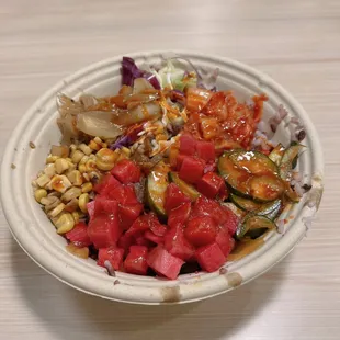 Bibimbap bowl with purple rice, kimchi, radish, cucumber kinchi, roasted corn, onions, and mixed salad(?)