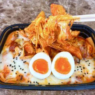 DELIVERY- Rose Tteokbokki: Creamy Rice Cakes w/ kimchi, fish cakes ($14.50), cheese (+$3), sausage (+$3). Added egg &amp; sesame seeds at home.