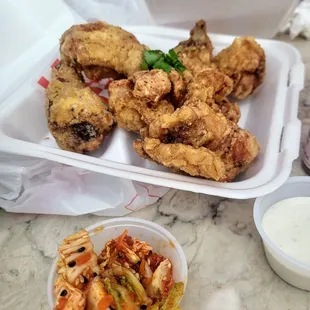 a tray of fried chicken and a bowl of sauce