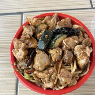Spicy chicken with half lo mein and fried rice .