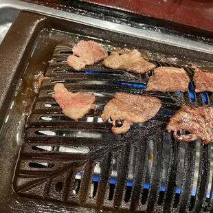 a grill with steaks on it