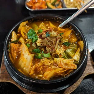 a bowl of soup with chopsticks