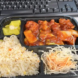 a tray of rice, vegetables, and meat
