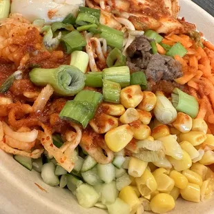a plate of noodles, meat, and vegetables