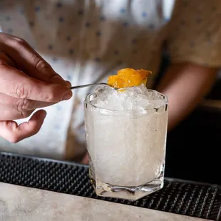 a bartender preparing a drink at a bar