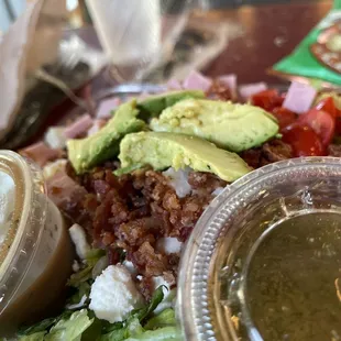Cobb Salad with balsamic vinaigrette and Greek dressing. Avocado cut with stem still attached.