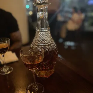 a decanter and a glass of wine on a table