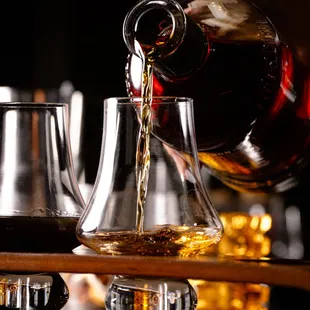 a person pouring a glass of wine