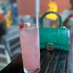 a pink cocktail with a strawberries garnish
