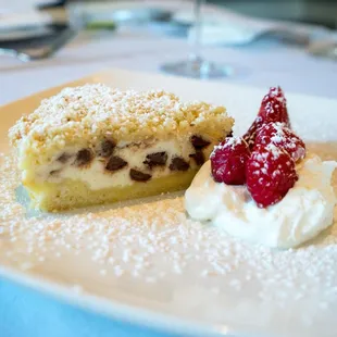 a piece of cake with whipped cream and raspberries