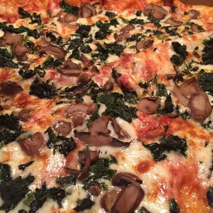 a pizza with mushrooms and spinach