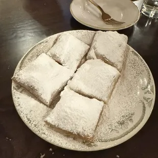 a plate of sugared squares on a table