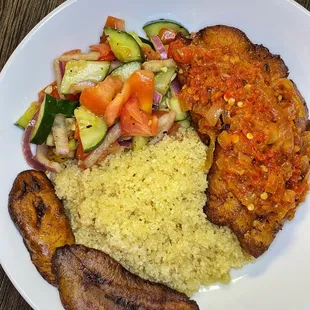 Attieke and fish with house salad, pepper sauce, and ripe plantains