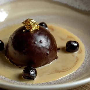 CIOCCOLATO FONDENTE | chocolate mousse bomb, almond cookie base, bourbon crème anglaise, Amarena cherry, gold leaf