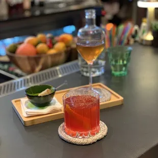 a glass of wine and a drink on a bar