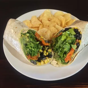 Vegan sweet potato, corn, black bean, avocado and arugula wrap with kettle cooked potato chips.