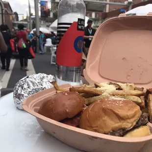 a hamburger and fries in a container