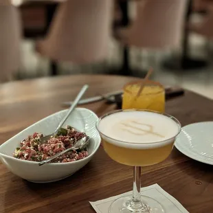 a bowl of food and a drink on a table