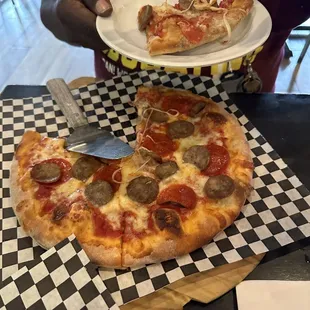 Bambino pizza with pepperoni and Italian sausage.