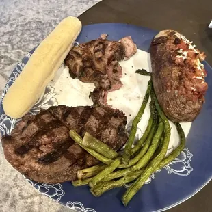 Ribeye, asparagus, breadstick, and loaded potato.